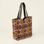 Close-up of Jat Mutava Suf embroidery yellow red diamond detail on black tote