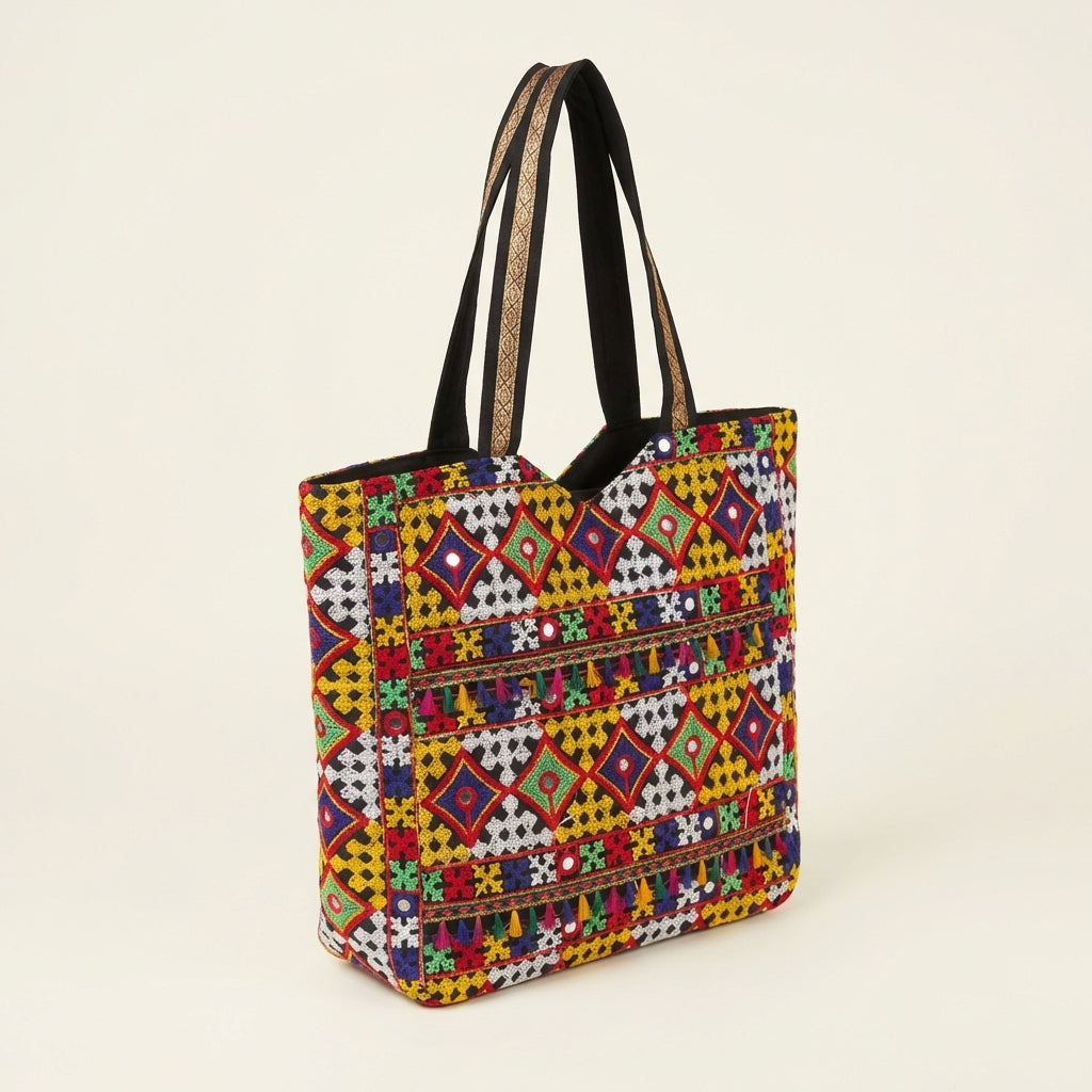 Close-up of Jat Mutava Suf embroidery yellow red diamond detail on black tote