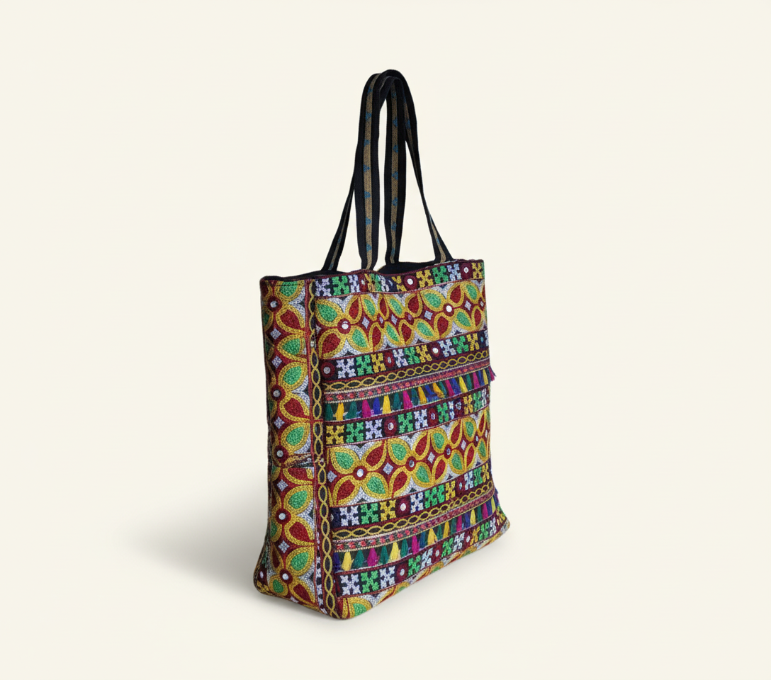 Close-up of Jat Mutava Suf embroidery red yellow leaf detail on black tote