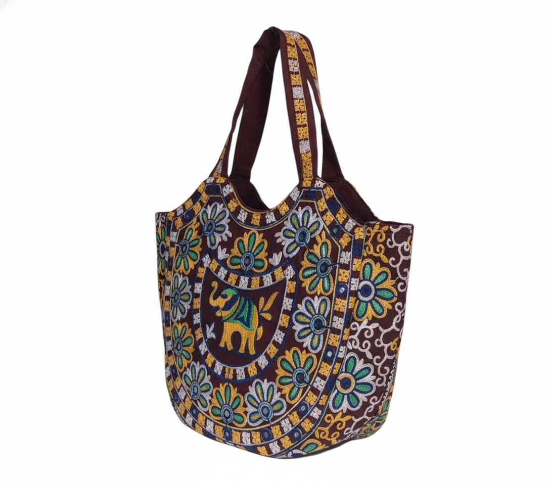 Close-up of Rabari embroidery elephant motif and mirror work on maroon tote