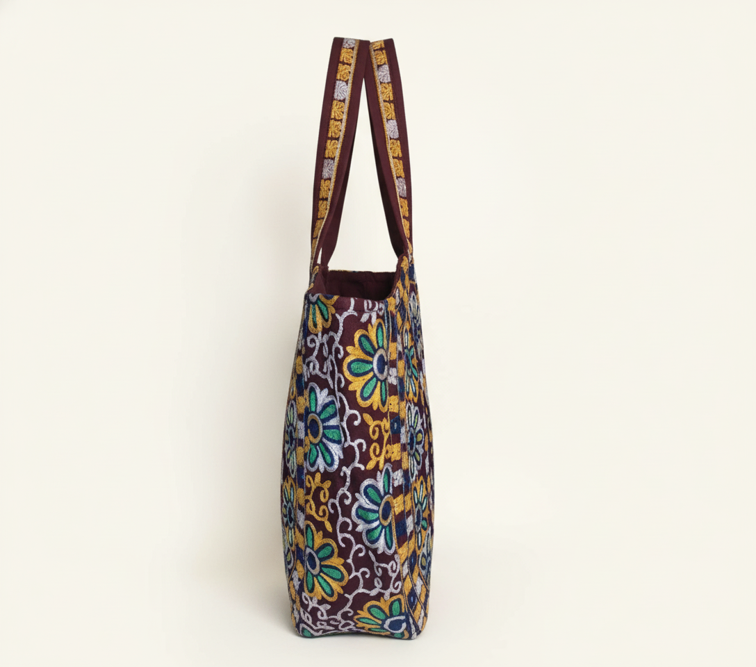 Model carrying Rabari embroidery maroon elephant tote bag — boho style