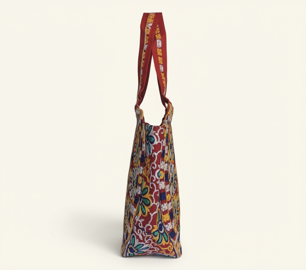 Model walking with Rabari embroidery red peacock tote bag — lifestyle shot