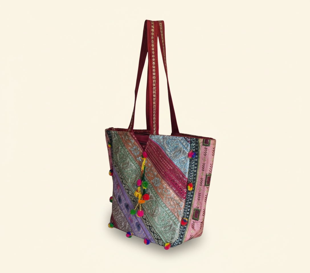 Close-up of Crimson Radiance gotta patti mirror and tassel detail on tote bag