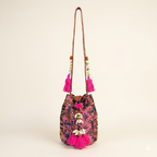Model walking with Shell Tassel Fuchsia Spark (Mini) bucket bag — lifestyle shot