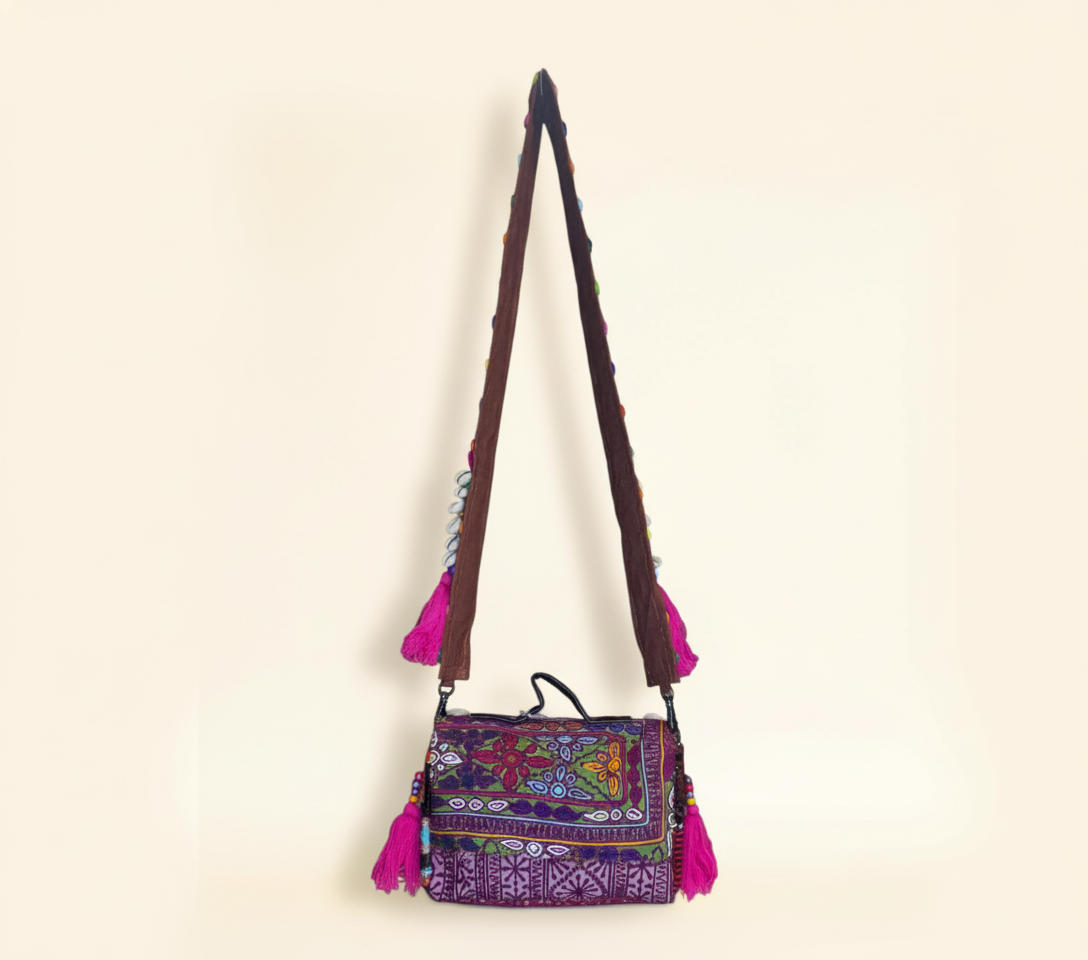 Close-up of Gulabi Aag cowrie shell & tassel detail