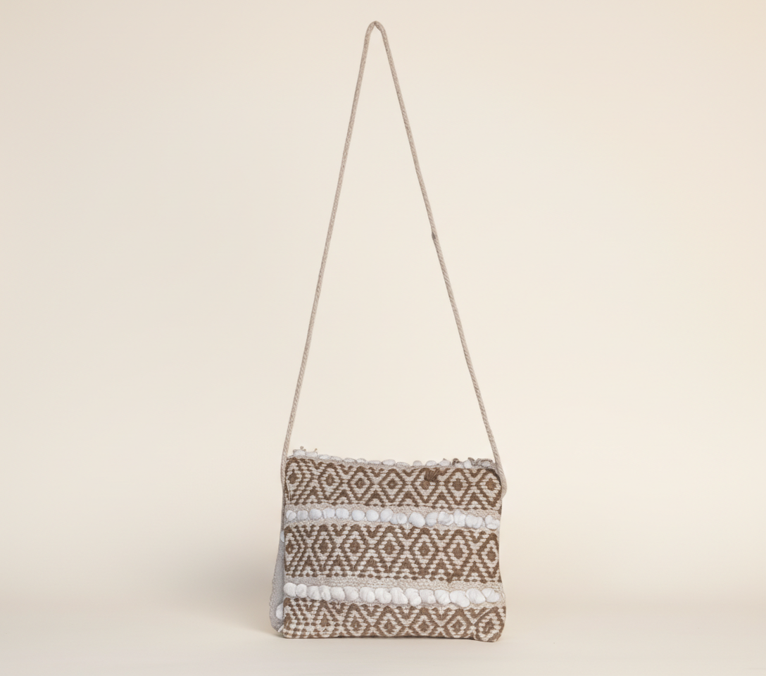 Model carrying Woven Earth Dune Lattice sling bag — boho style