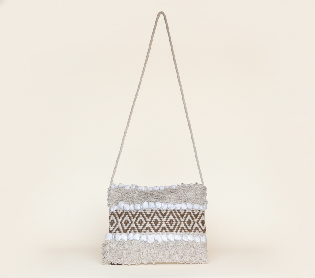 Model carrying Woven Earth Desert Grid sling bag — boho style