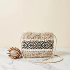 Model walking with Woven Earth Obsidian Weave sling bag — lifestyle shot