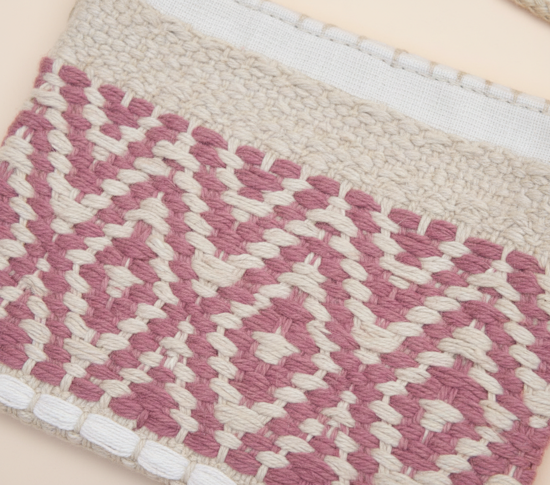 Close-up of Blush Lattice artisan weave texture on sling bag